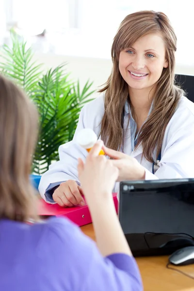 Close-up van een aantrekkelijke vrouwelijke arts houden geneeskunde — Stockfoto