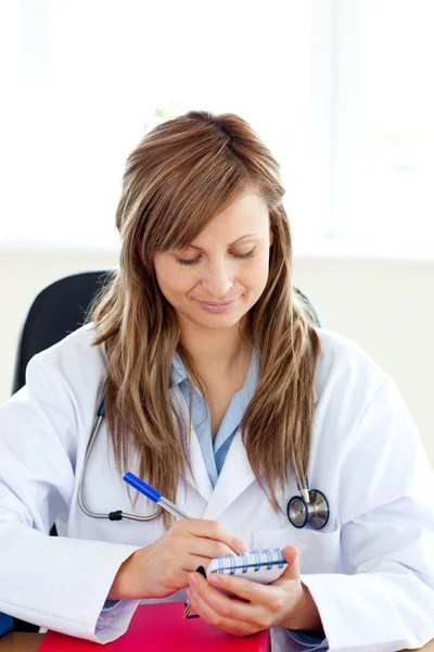Szczęśliwy kobiece kobieta lekarz pisze jej diagnoza — Zdjęcie stockowe