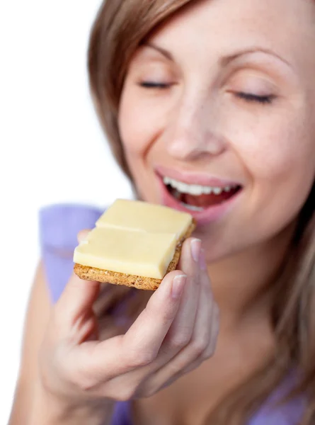 Jonge vrouw een cracker met kaas eten — Stockfoto