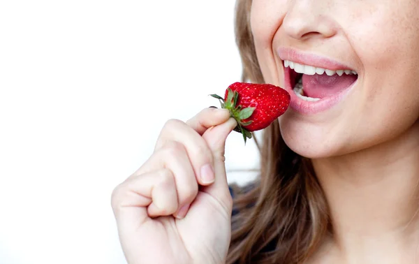 Primer plano de una mujer joven comiendo una fresa — Foto de Stock
