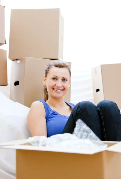 Mujer sonriente teniendo un descanso entre cajas — Foto de Stock