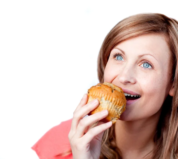 Vrolijke vrouw is eten een muffin — Stockfoto