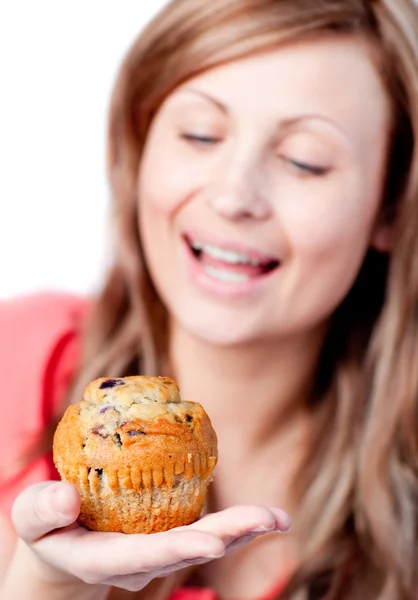 Stralende vrouw is eten een muffin — Stockfoto