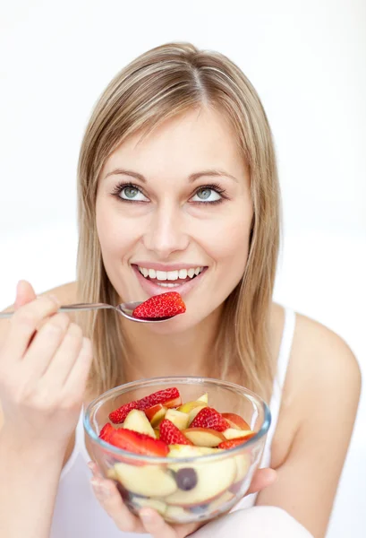 Jolly woman eating fruit salad — Stockfoto