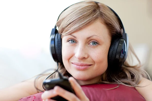 Ontspannen vrouw luistert de muziek in de woonkamer — Stockfoto