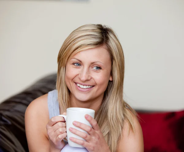 백인 여자는 소파에 커피 한 잔을 마시는 — 스톡 사진