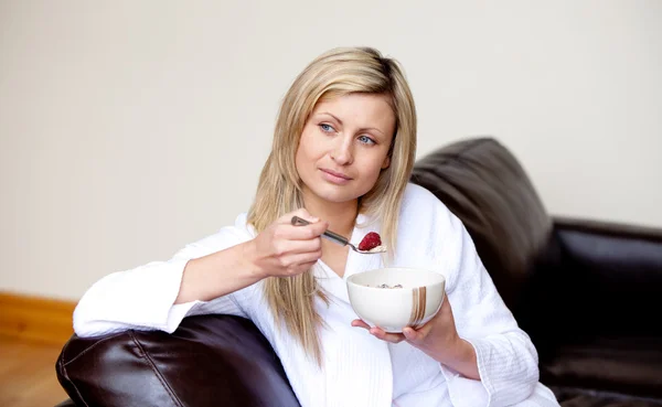 Kaukasisk kvinna med en frukost på en soffa — Stockfoto