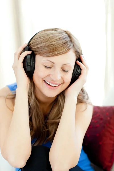Mooie vrouw luistert de muziek in de woonkamer — Stockfoto