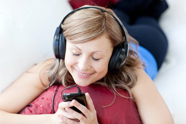 즐거운 여자는 거실에서 음악을 듣고는 — 스톡 사진
