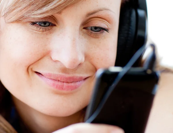 Retrato de una mujer encantada escuchando la música con auriculares — Foto de Stock