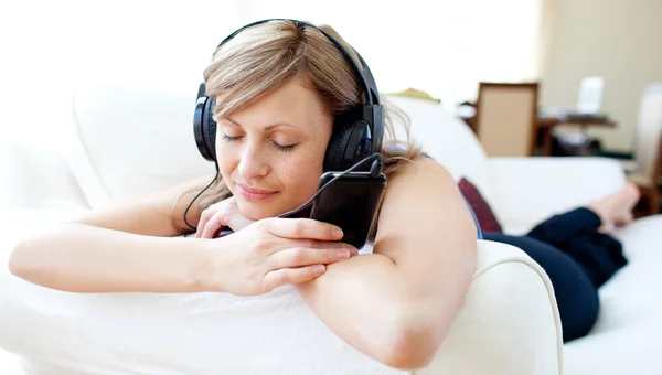 Retrato de una mujer brillante escuchando la música con auriculares — Foto de Stock