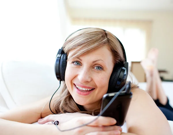 Retrato de uma mulher alegre ouvindo a música com fones de ouvido — Fotografia de Stock