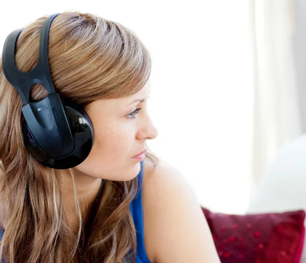 Mulher radiante está ouvindo a música com fones de ouvido — Fotografia de Stock