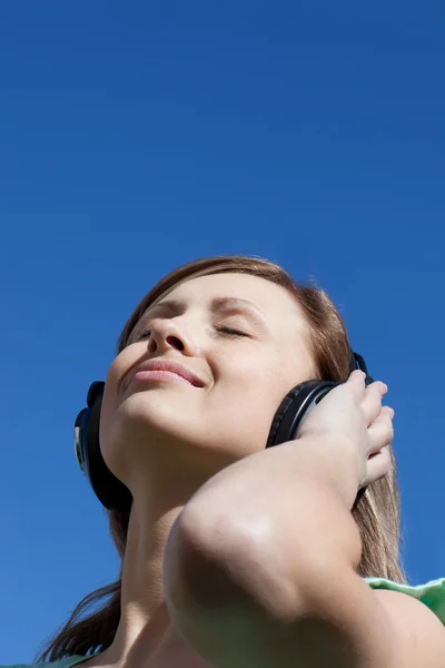 Strahlende Frau hört draußen Musik — Stockfoto