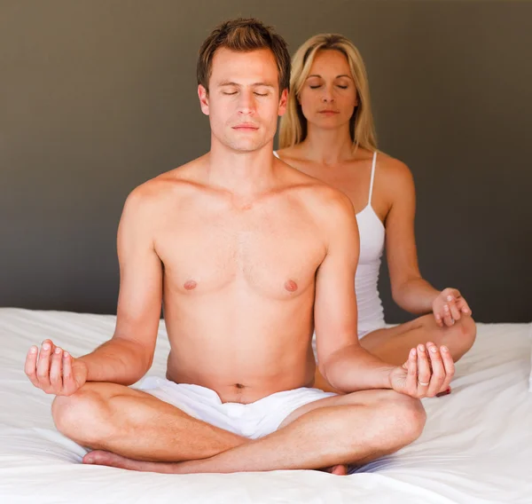 Portrait of a couple doing exercises on bed Stock Image