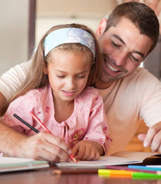 Cheerful father helping her daughter for homework Stock Photo