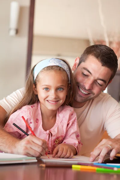 Cheerful father helping her daughter for homework Stock Picture