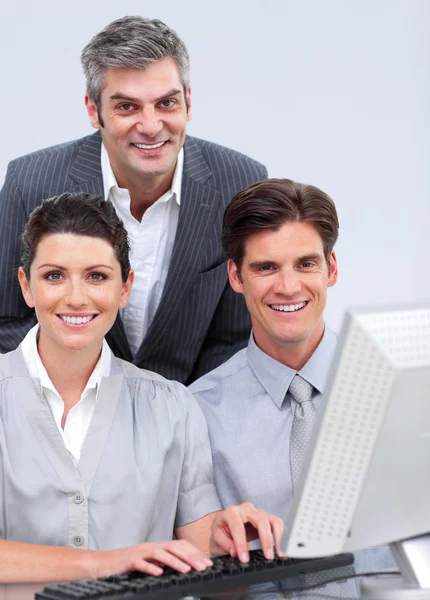 Положительная деловая команда, работающая за компьютером Стоковое Изображение