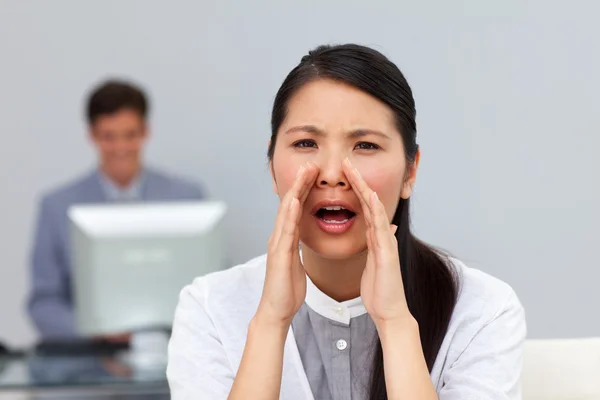 Angry businesswoman shouting in the office Stock Photo