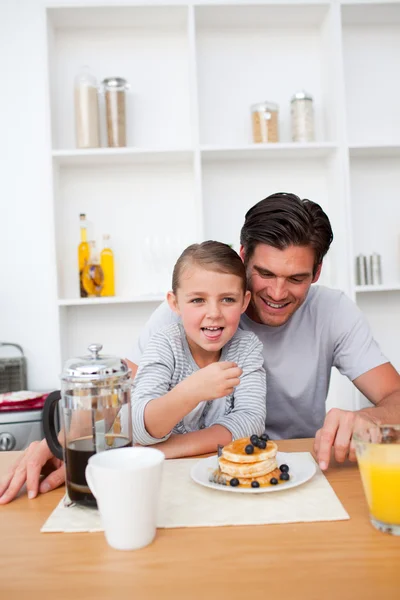 Porträtt av en far och hans dotter äter frukost Stockbild