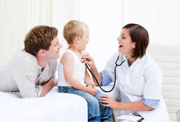 Radiant female doctor examining a little boy with his father — Stock Photo, Image