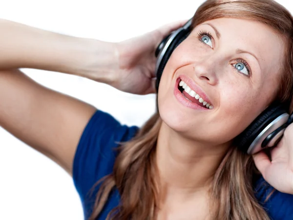Glad kvinna lyssnar musik med hörlurar Stockbild