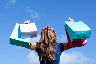 Young woman holding shopping bags outdoor clipart
