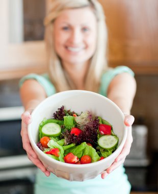 Happy woman showing a salad clipart