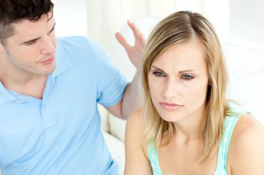 Young couple having an argue in the living-room clipart