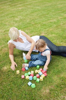 Handsome mother playing with her child clipart