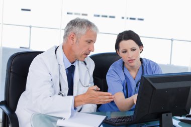 Professional medical team working with a computer clipart