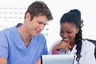 Happy doctors looking at a document clipart