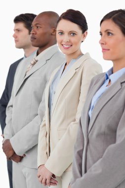 Smiling businesswoman standing between her associates clipart