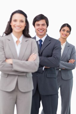 Smiling salesteam standing together with folded arms clipart