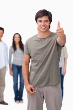 Smiling man giving thumb up with friends behind him clipart