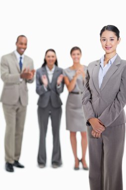 Close-up of a businesswoman with co-workers applauding in the ba clipart