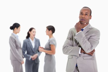 Thoughtful businessman looking up with co-workers clipart