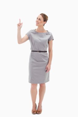 Smiling woman in dress showing something above with her hand clipart