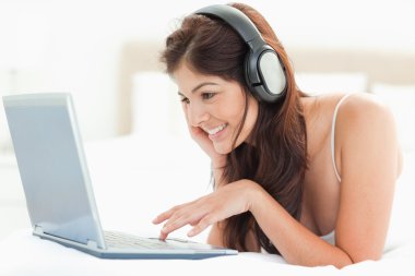 Smiling woman using the mouse pad to scroll on a laptop while we clipart