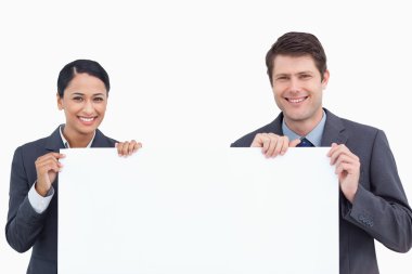 Close up of smiling salesteam holding blank sign clipart