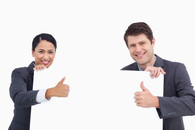 Close up of salesteam with blank sign giving thumbs up clipart