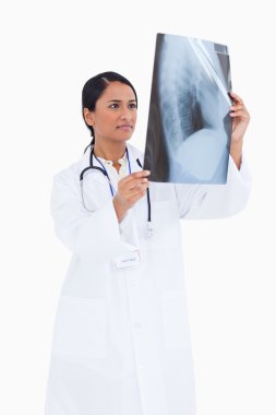 Female physician taking a look at x-ray clipart