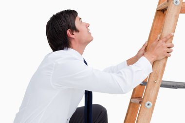 Side view of young tradesman climbing on a ladder clipart