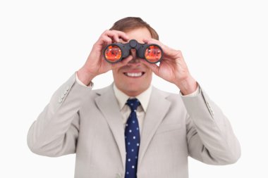 Smiling businessman using binoculars clipart