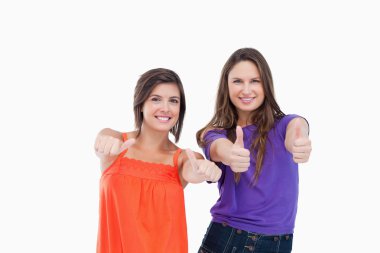 Woman standing up her thumbs turned to the side while her friend clipart