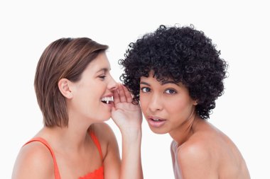 Teenage girl being told a secret by a friend clipart