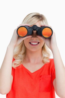 Smiling woman looking through binoculars clipart