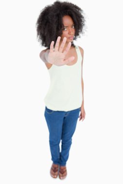 Young woman standing upright while making the hand stop sign clipart
