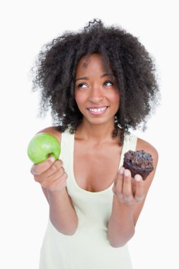 Young woman looking up to ask for help to choose between a fruit clipart