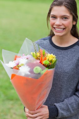 Young girl holding a bunch of flowers clipart